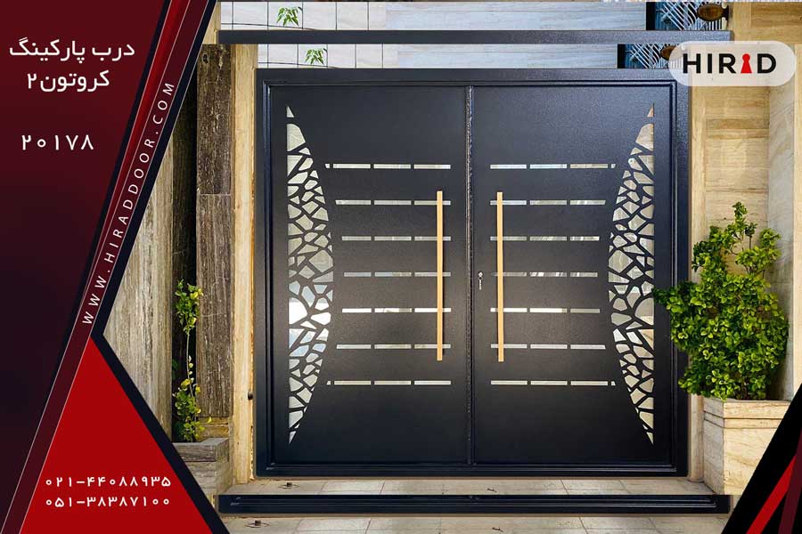 درب فلزی دو لت مشکی زنگ، با برش های ظریف و زیبا، دارای دو دستگیره چدنی طلایی رنگ، نصب شده در ورودی ساختمان ویلایی با نمای سنگ